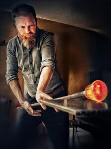 William Manson marvers a punty of molten crystal.